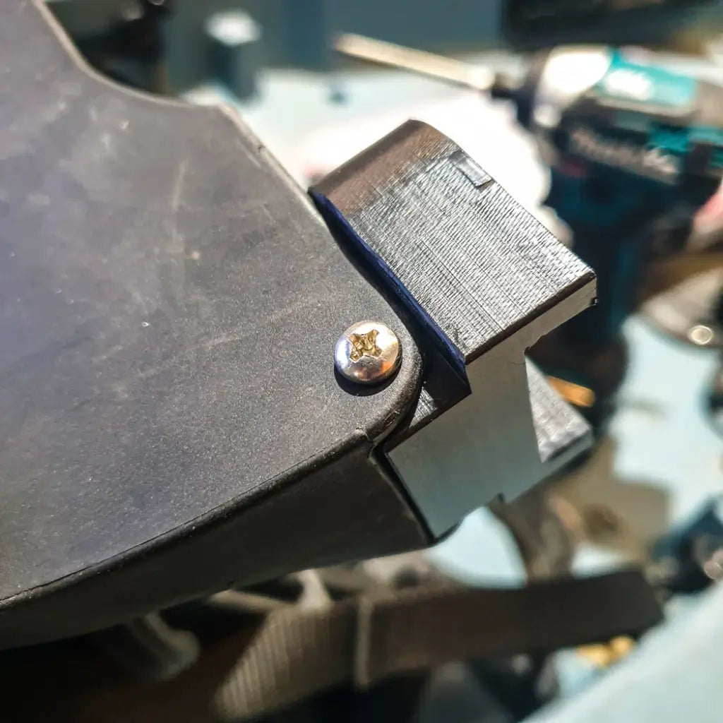 Close-up of a black seat riser block bolted between the Hobie Compass seat frame and deck