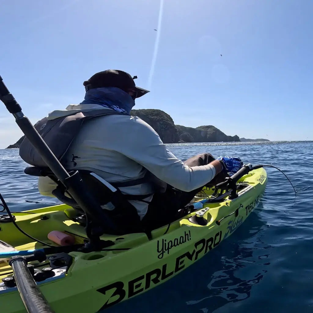 Angler fishing from an Seagrass green Hobie Outback with a BerleyPro hull decal