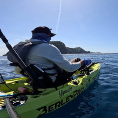 Angler fishing from an Seagrass green Hobie Outback with a BerleyPro hull decal