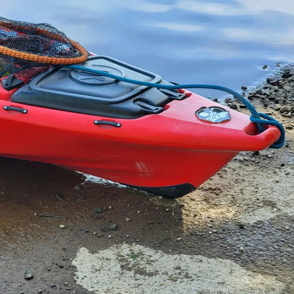 Red Jackson Knarr FD kayak pulled up on a rocky shoreline with the Bumper Bro on its bow
