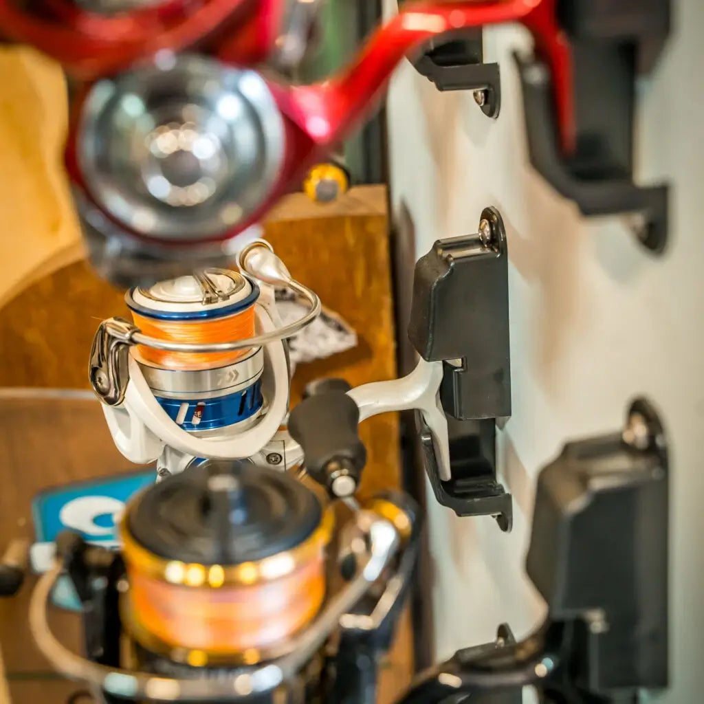 Close-up of orange and silver spinning reels docked on black Reel Dock holders