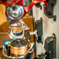 Close-up of orange and silver spinning reels docked on black Reel Dock holders