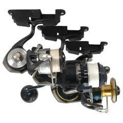 Several spinning reels hanging by their feet from black Reel Docks on a white backdrop