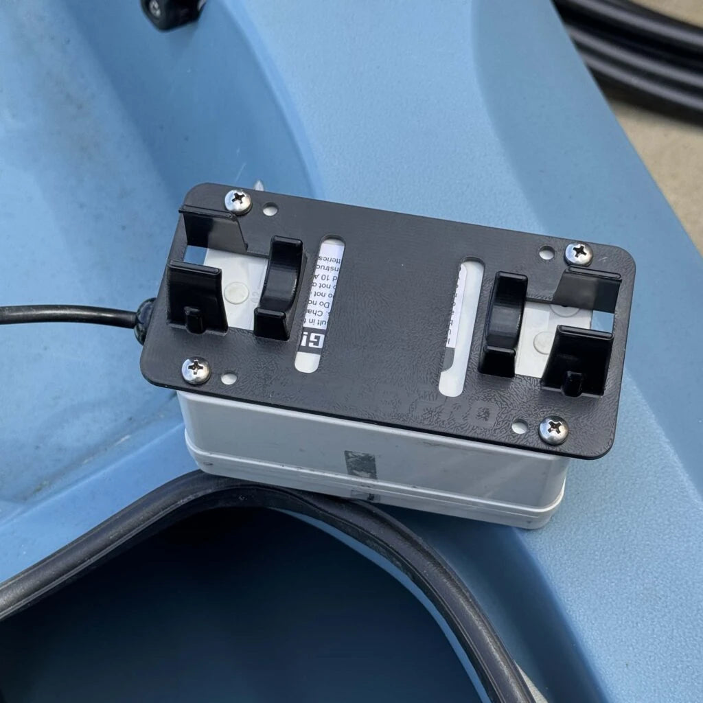 Empty battery mast mount bracket clamped around the mast base of a blue Hobie kayak