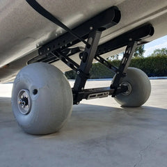 Kimmi Cart kayak trolley with balloon wheels under a dune Hobie Outback, side view on concrete